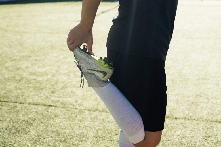 woman in black shorts and white socks stretching her leg