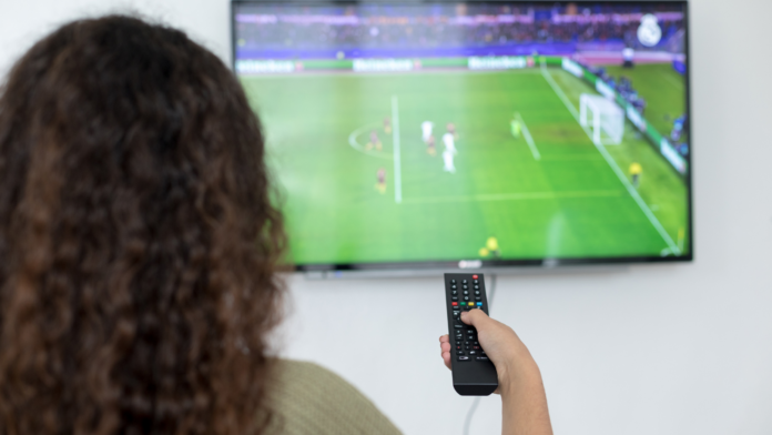 Personne devant sa télévision qui regarde un match de football féminin