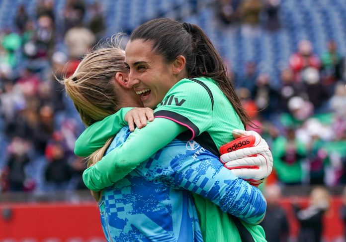 deux joueuses du boston legacy fc qui se prennent dans les bras de joie suite à leur première victoire